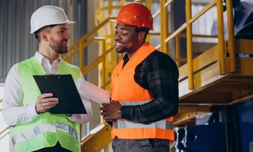 Inspector and african american worker in a factory Health and safety in a construction environment
